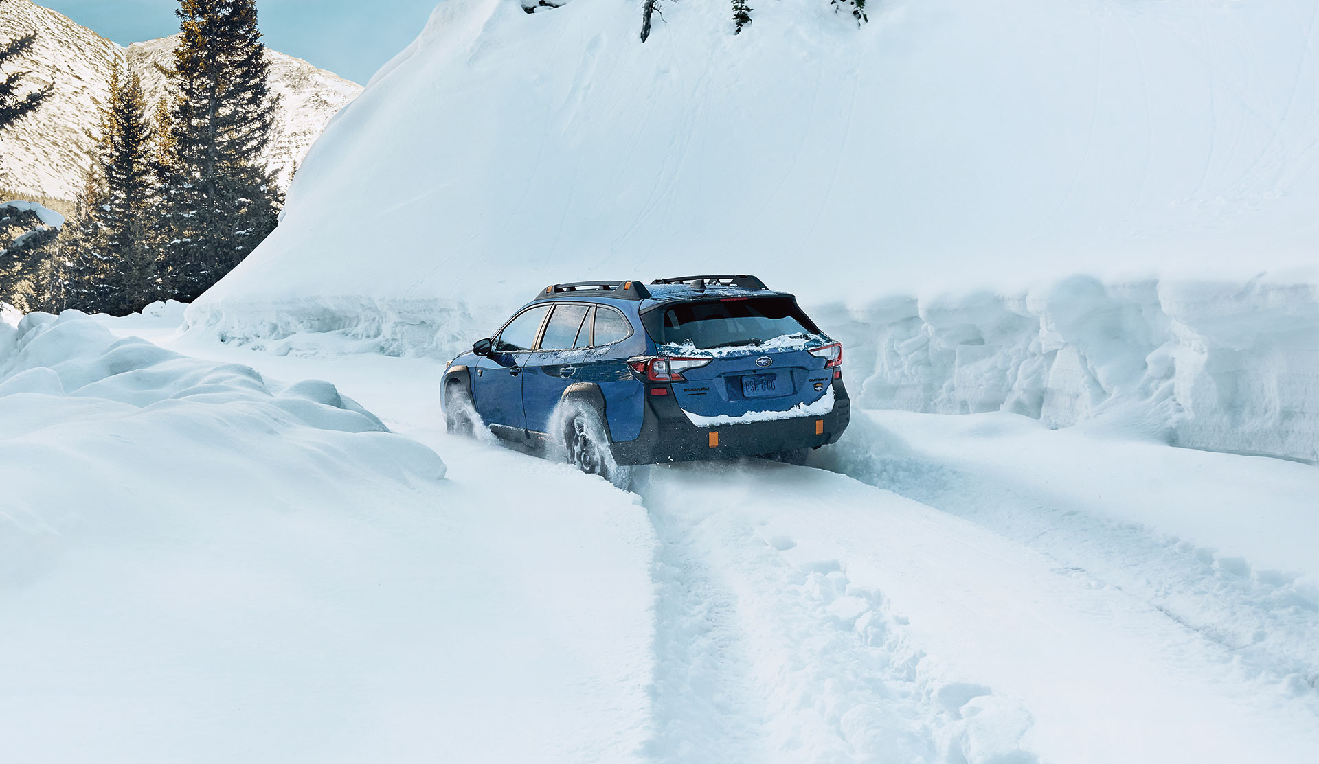 Rear shot of 2025 Outback Wilderness driving in deep snow